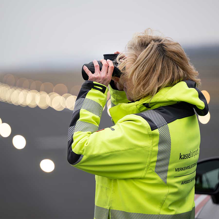 Mitarbeiterin vor dem Rollfeld am Kassel Airport
