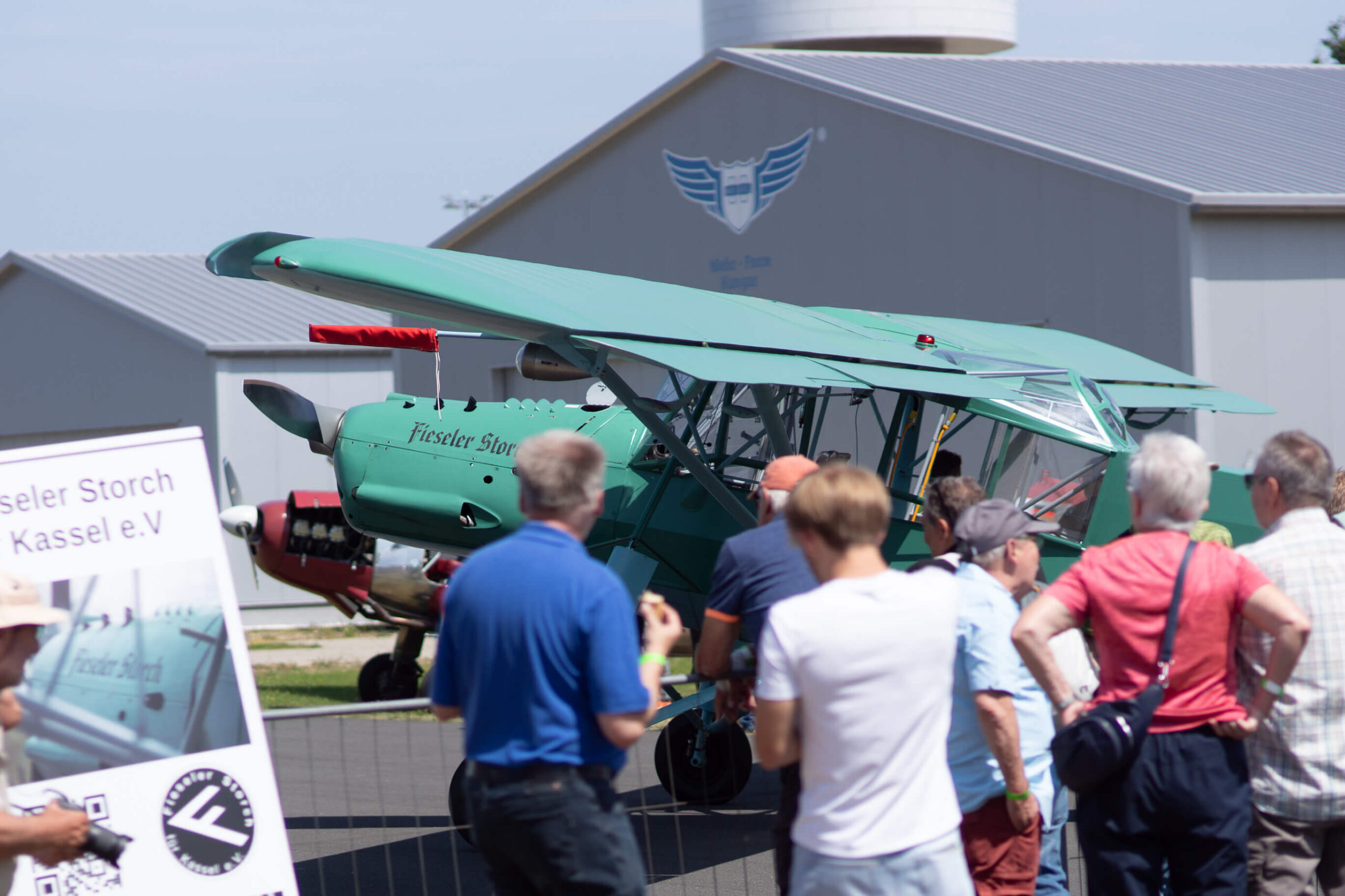 Personen schauen sich einen Fieseler Storch Flieger an